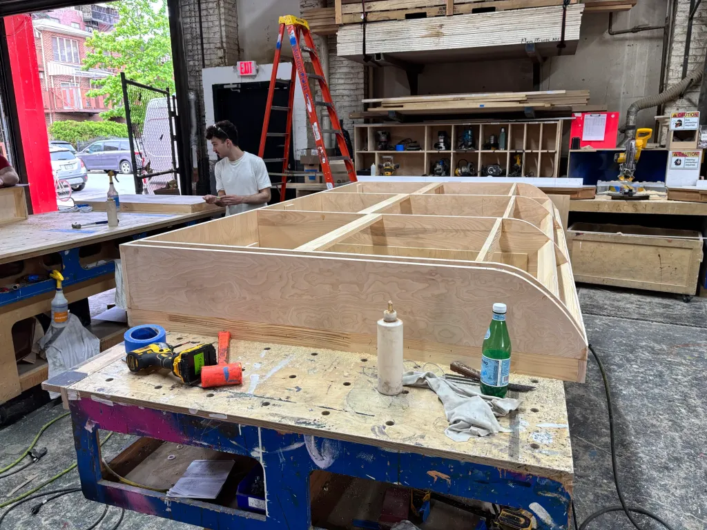 Wood framing for a curved game-booth roof in the shop