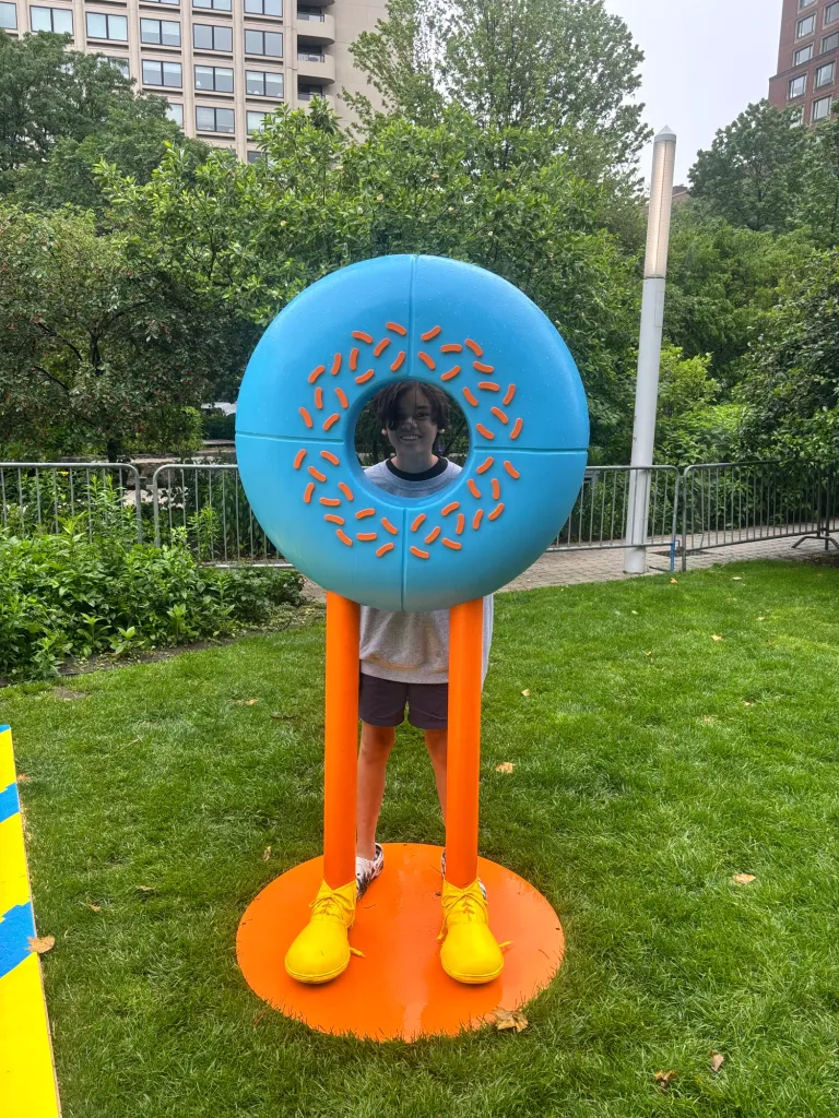 A finished donut character with orange legs and yellow shoes on the Greenway