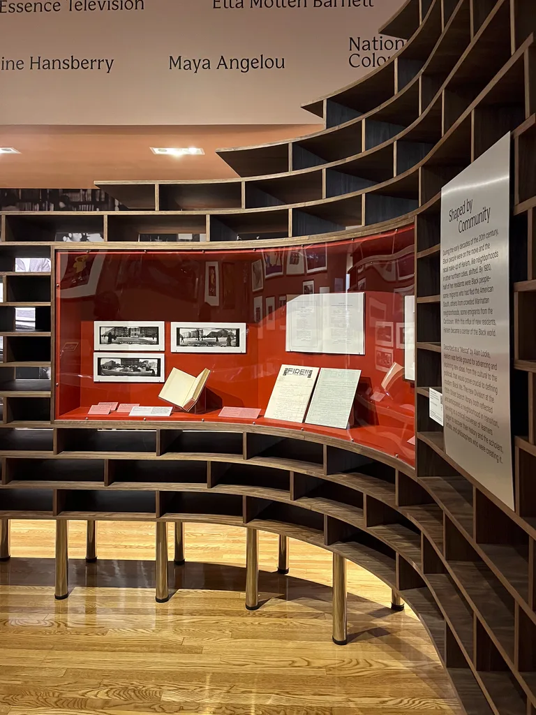 A red-lined vitrine set into the curved walnut display wall, with exhibition text panel
